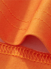 Orange toddler outfit detail showing fabric texture and stitching