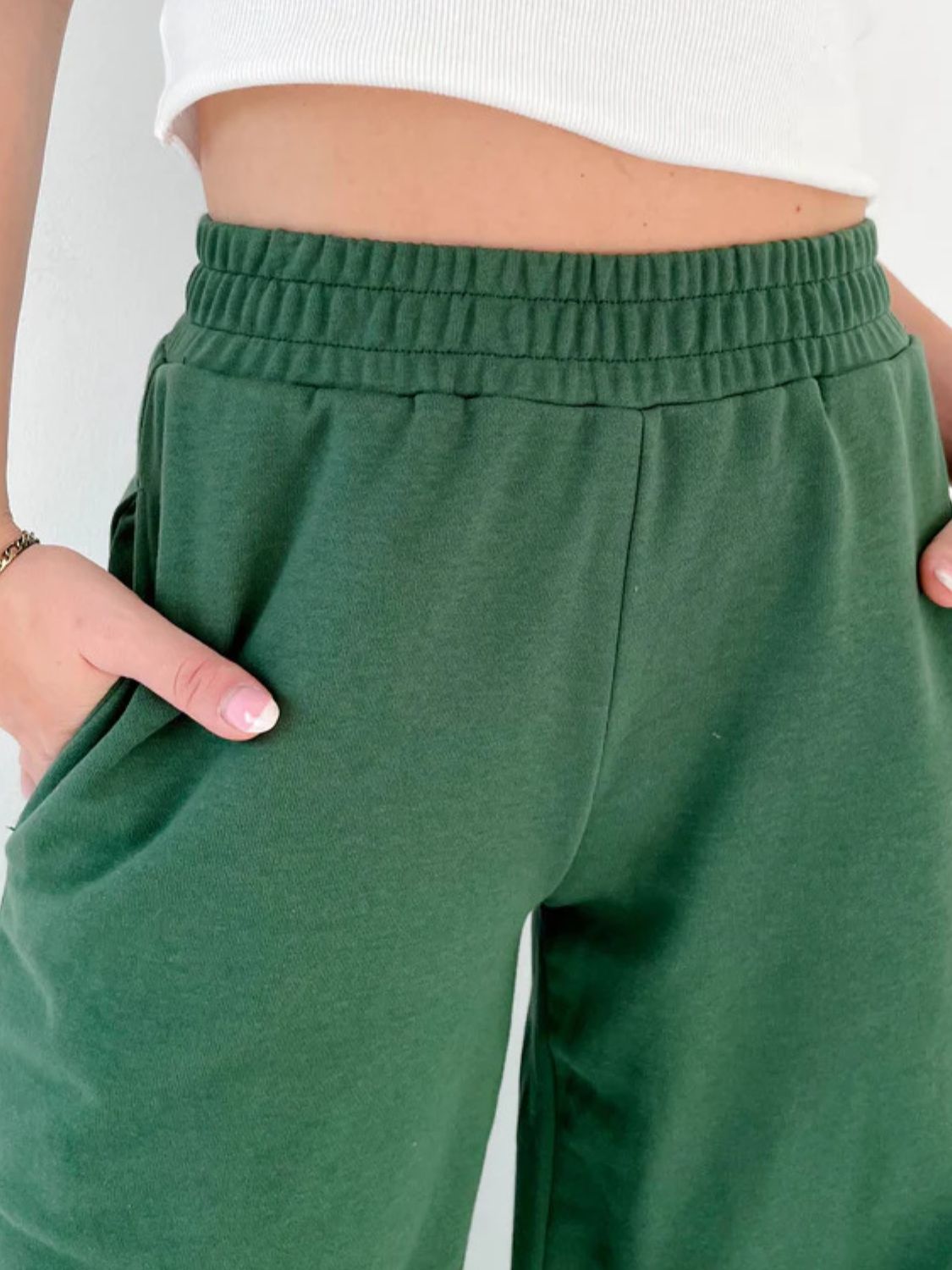 Dark green wide-leg lounge pants with elastic waistband and pockets.