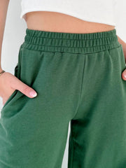 Dark green wide-leg lounge pants with elastic waistband and pockets.