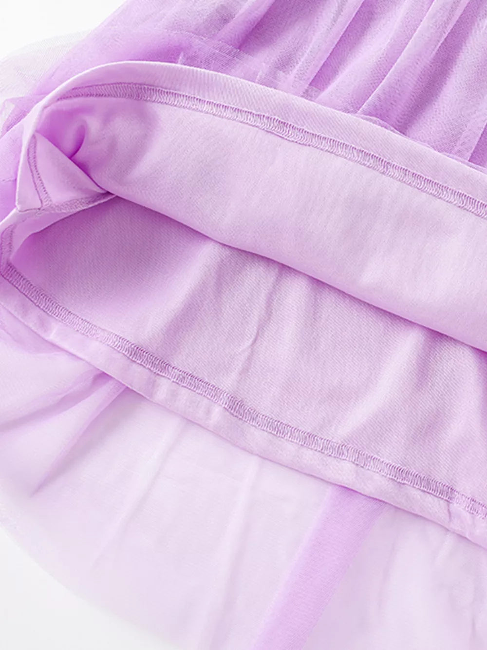 Toddler lilac embroidered floral tulle dress detail showing layered fabric and stitching.