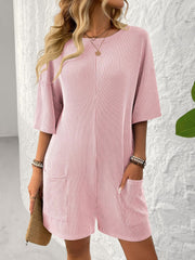 Blush pink ribbed knit romper with short sleeves, crew neck, and two front pockets.