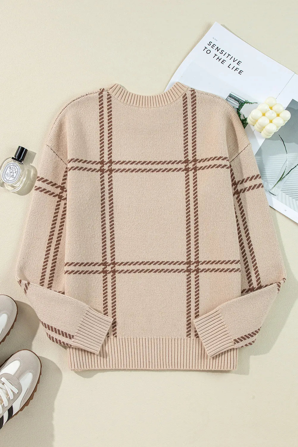 Tan crewneck knit pullover sweater with brown plaid pattern and ribbed cuffs and hem.