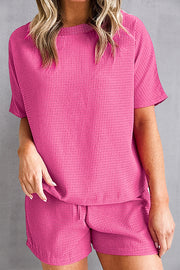 Hot pink waffle knit co-ord set with short sleeves and drawstring shorts.