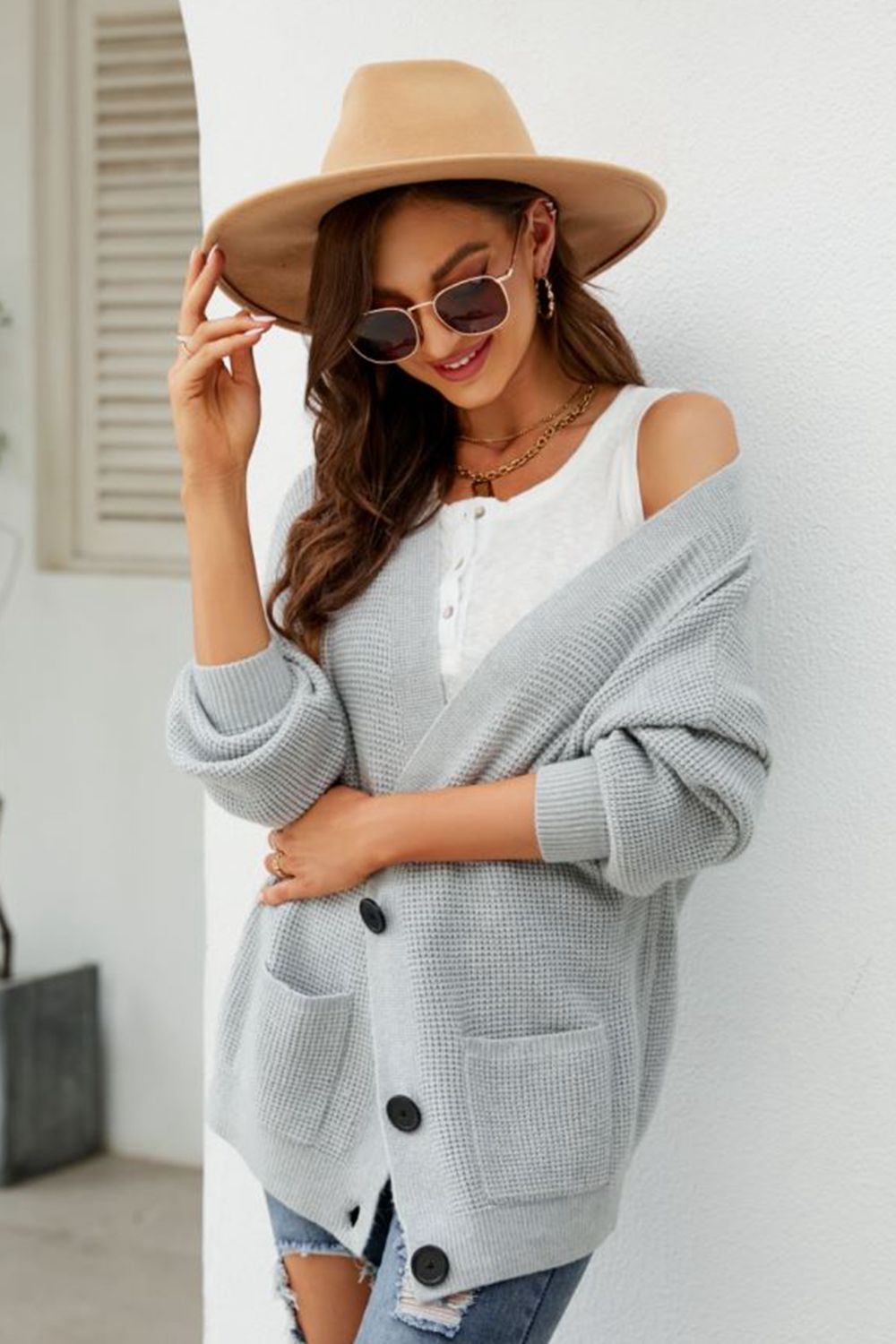 Light gray textured knit cardigan with oversized pockets and black buttons.