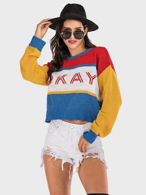 Colorblock knit sweater with "Okay" graphic, crew neck, and long sleeves.