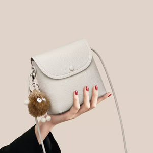 White pebbled pu leather crossbody bag with button closure and cute keychain
