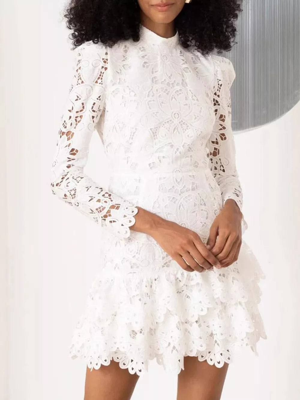 White lace mock neck mini dress with tiered ruffled skirt and scalloped hem.