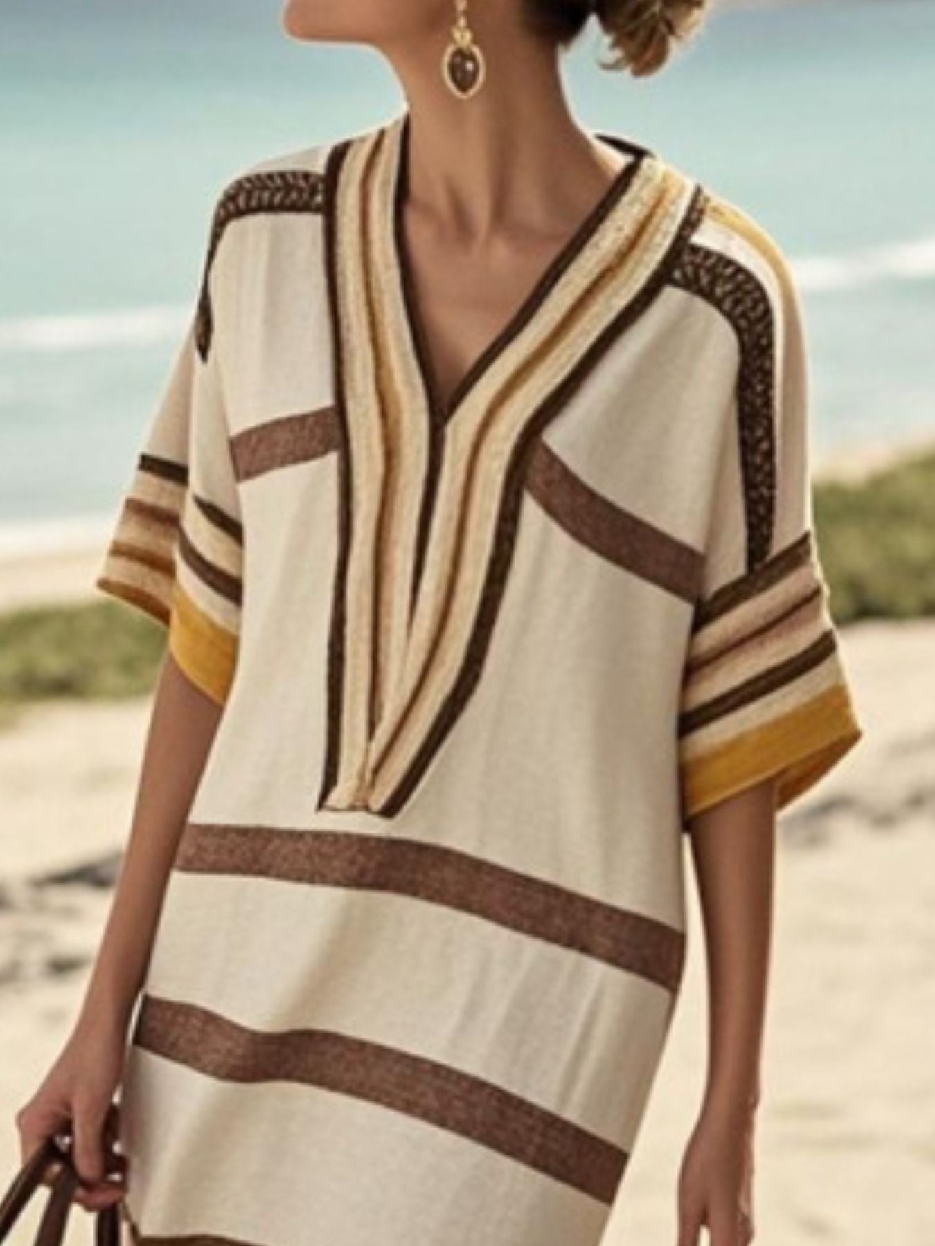 Striped midi dress in tan with brown and yellow accents, V-neck, half sleeves, and textured trim.