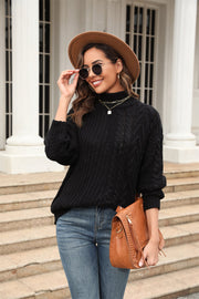 Black cable-knit turtleneck sweater with voluminous silhouette and textured acrylic fabric.