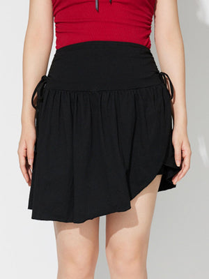 Black draped wrap mini skirt with asymmetric hem and tie detail.