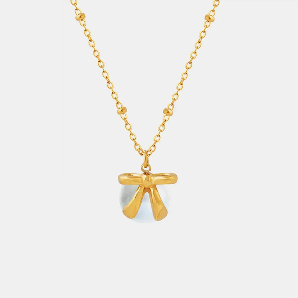 Gold bow accent necklace with pearl drop pendant
