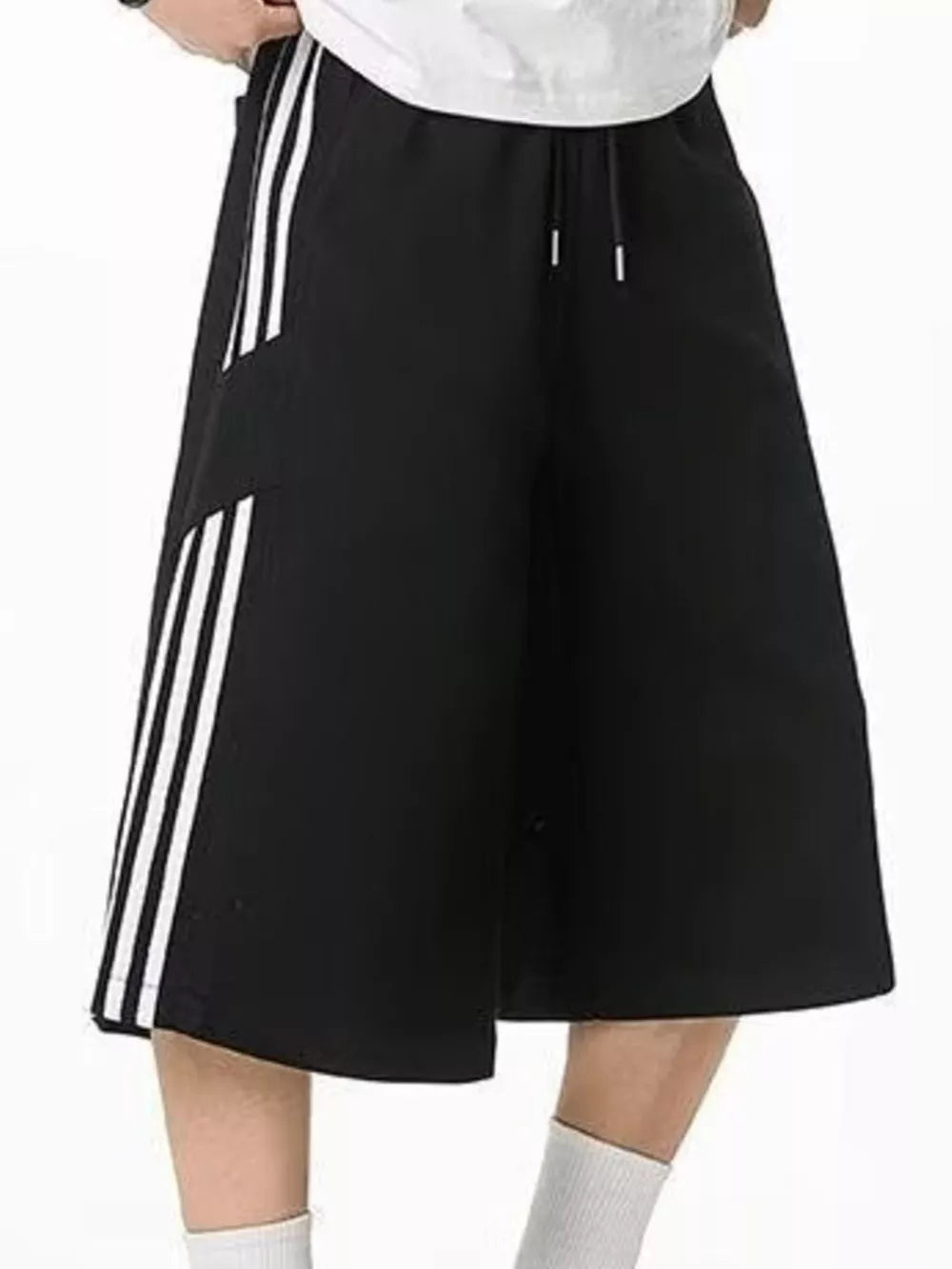 Black cropped sweatpants with white side stripes and drawstring waist.