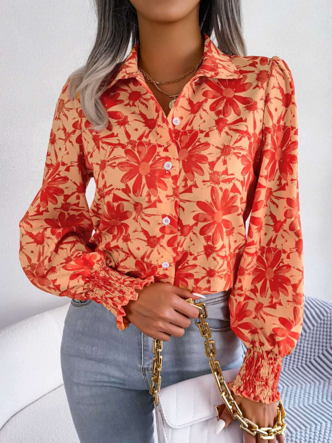 Floral print blouse in pumpkin with shirred cuffs and button front.