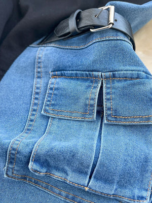 Blue denim midi dress with utility pockets and a black belted waist.