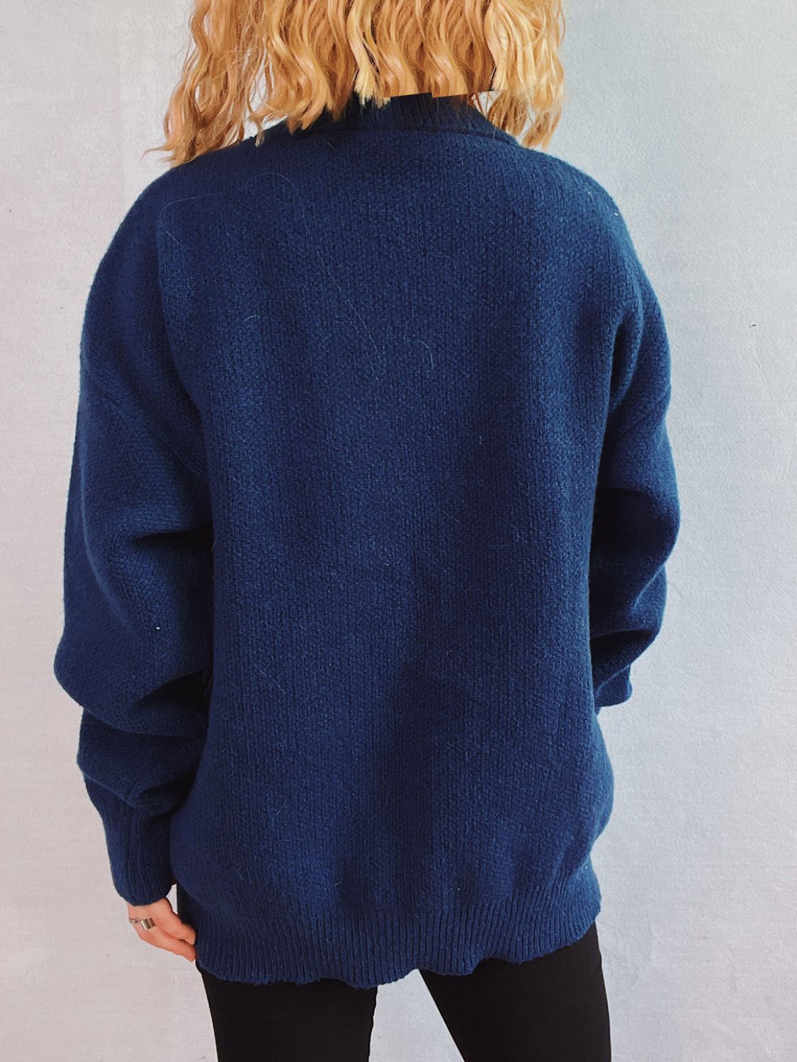 Dark blue acrylic knit sweater with a crew neckline and long sleeves.