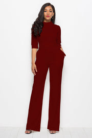 Burgundy high-neck belted palazzo jumpsuit with 3/4 sleeves and pockets.