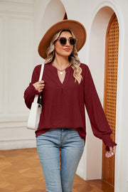Wine eyelet detail poet sleeve blouse with split neckline and smocked cuffs.