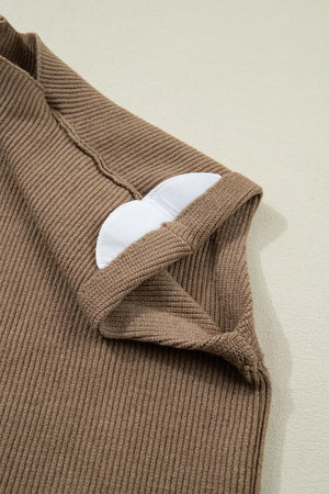 Brown ribbed knit mock neck sweater vest with white padded cups visible at the neckline.