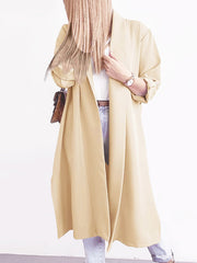 Pastel yellow draped-front maxi trench coat with button cuffs and a relaxed fit.