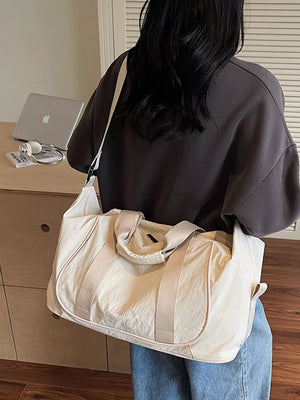 Cream white lightweight oxford cloth duffel bag with dual handles and shoulder strap.