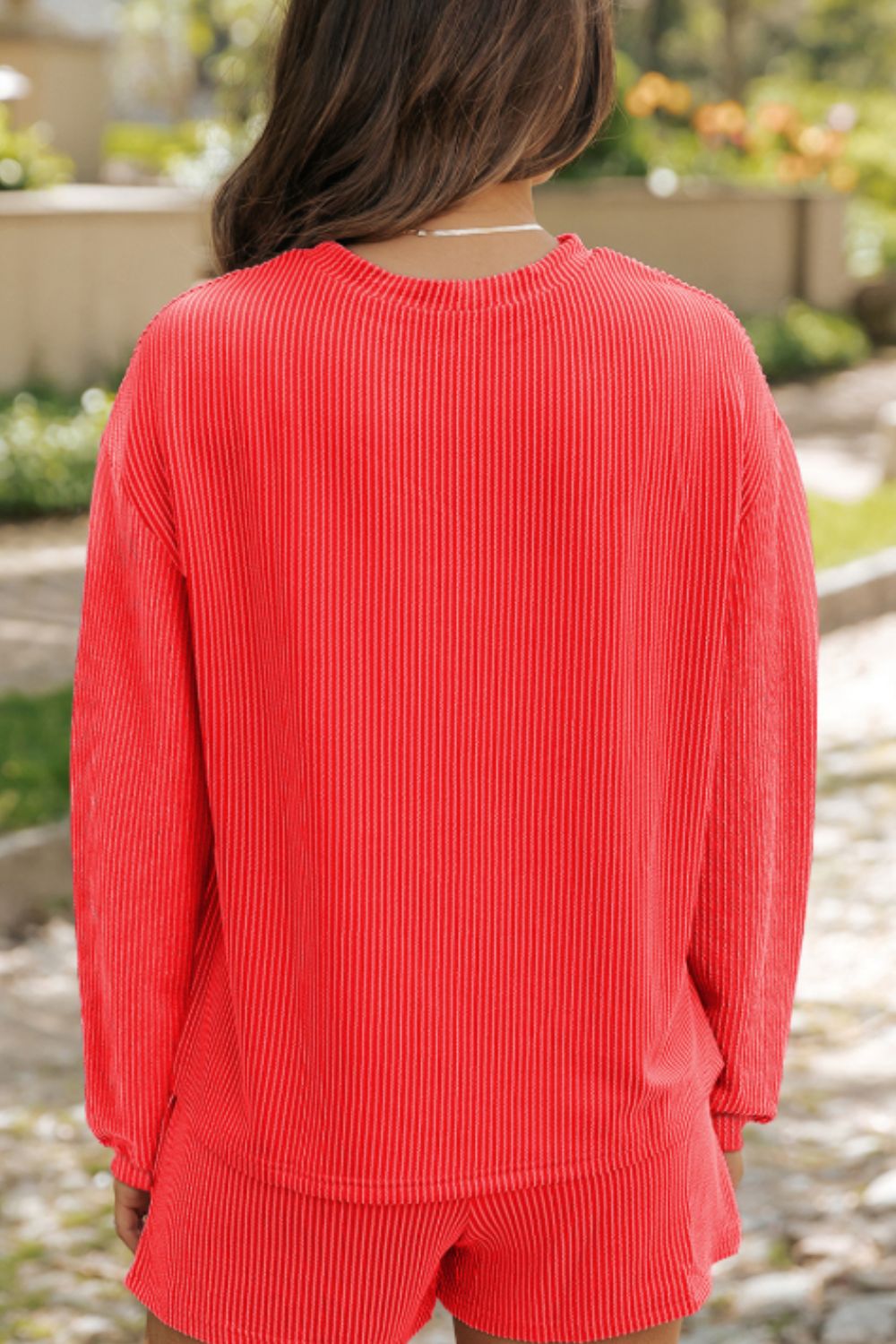 Orange-red ribbed lounge set with crew neck long sleeve top and shorts.