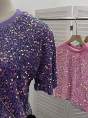 Purple crew neck t-shirt with iridescent sequin embellishments and textured fabric.