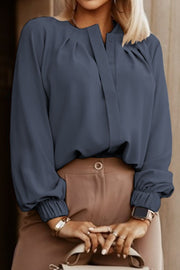 Misty Blue pleated yoke blouse with button detail and elastic cuffs.