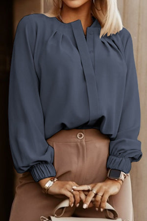 Misty Blue pleated yoke blouse with button detail and elastic cuffs.