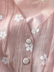 Dusty pink midi dress with white floral embroidery and button details.