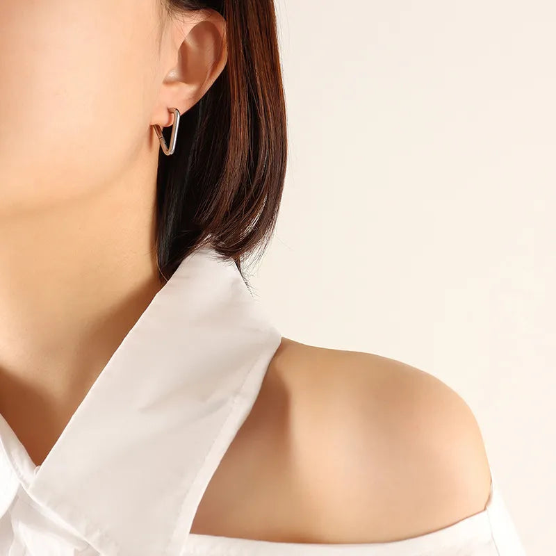 Silver sharp triangle huggie earrings made of steel.