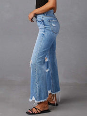 Chic distressed blue denim maternity flare jeans with raw hem and ripped details.