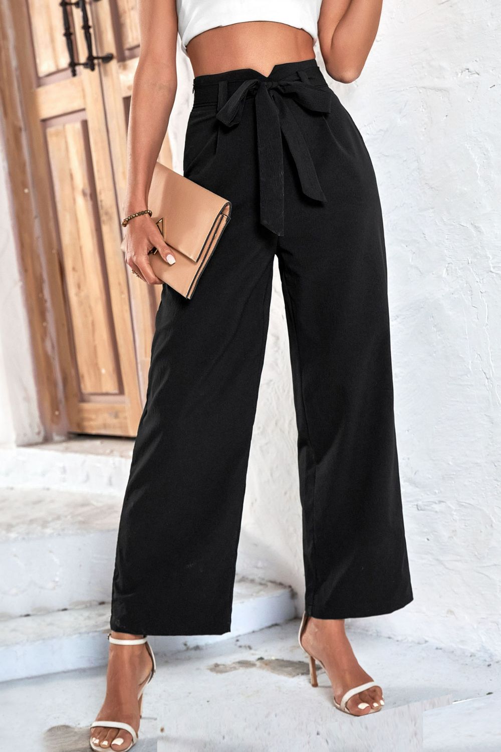 Belted high-waist palazzo trousers in black with a cinched bow tie waist and wide leg