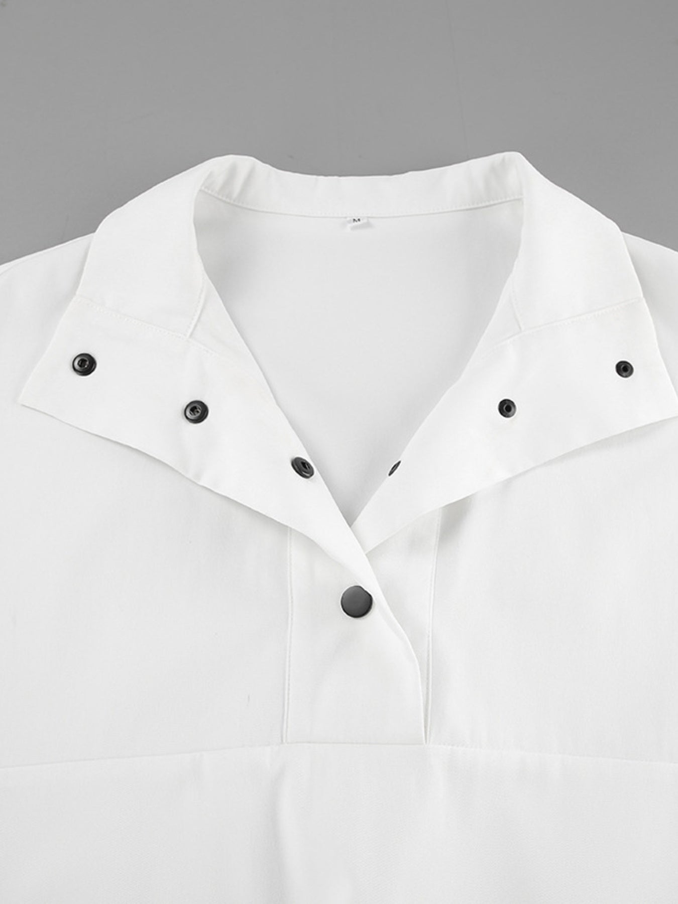 White two-piece set with snap details and a collared neckline.