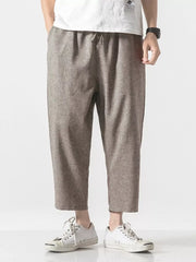Men's relaxed fit cropped sweatpants in brown with drawstring waist and cuffed hem.