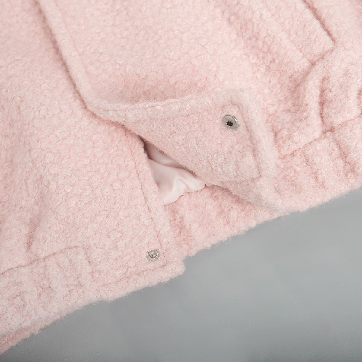 Textured blush pink bouclé bomber jacket with snap closure detail