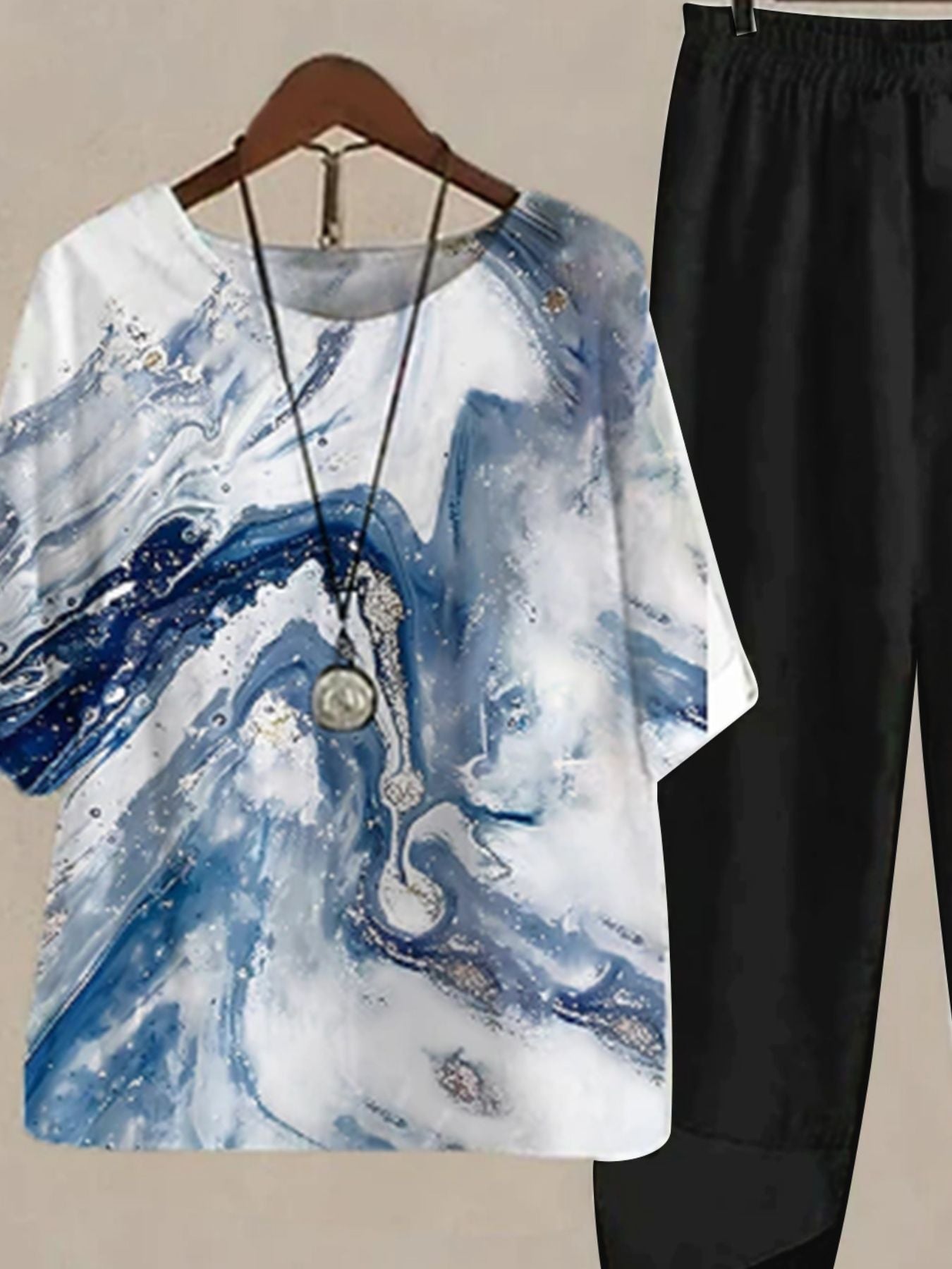 Floral print half sleeve top set in blue and white marble pattern with black pants.
