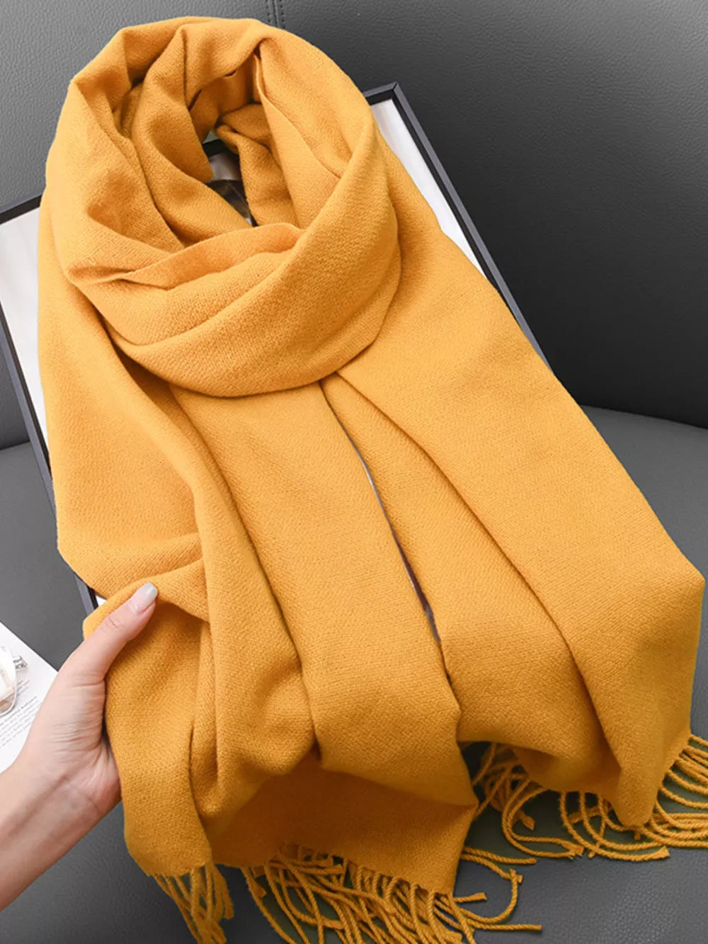 Yellow fringed scarf with a soft texture, styled loosely.
