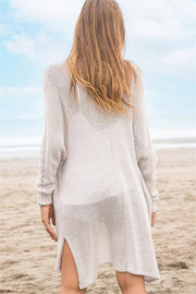 Open-knit beige acrylic cardigan with slit hem and long sleeves, shown from the back.