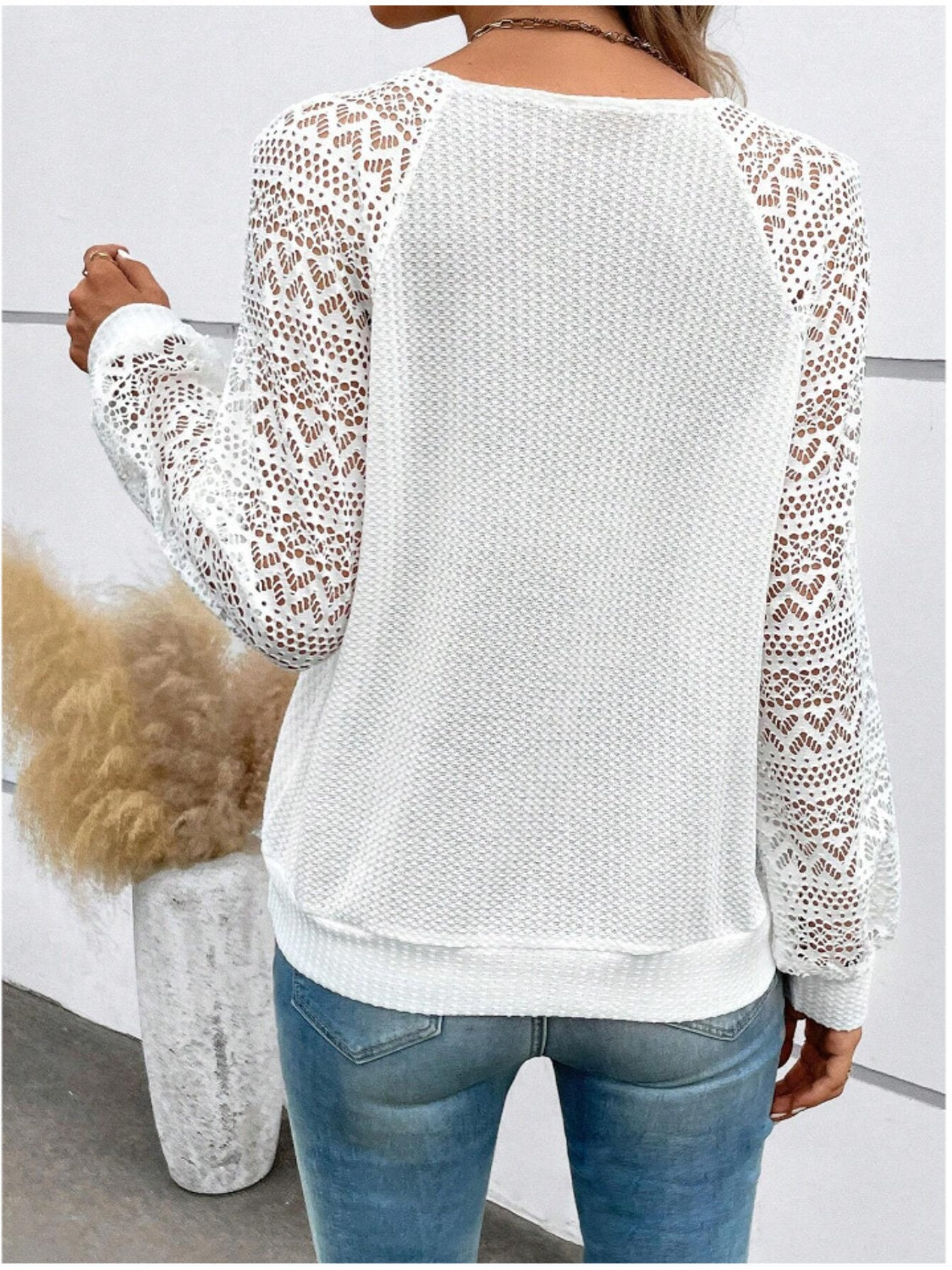 White waffle knit top with intricate lace sleeves and yoke detail.