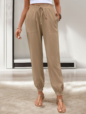 Tan linen-blend joggers with drawstring waist and gathered cuffs.
