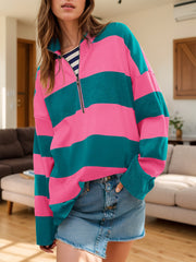 Oversized zip-up pullover with bold pink and teal stripes and a quarter zip neckline.