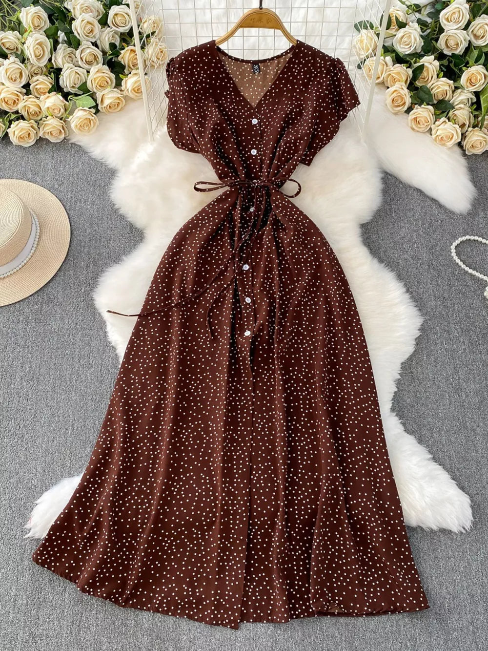 Brown polka dot maxi dress with V-neck, button front, short sleeves, and belt.