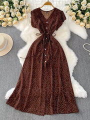 Brown polka dot maxi dress with V-neck, button front, short sleeves, and belt.