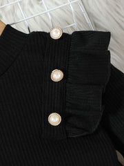 Black ribbed baby top with ruffled trim and decorative pearl buttons