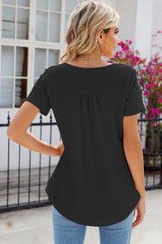 Black eyelet yoke gathered henley shirt with short sleeves and a curved hem.