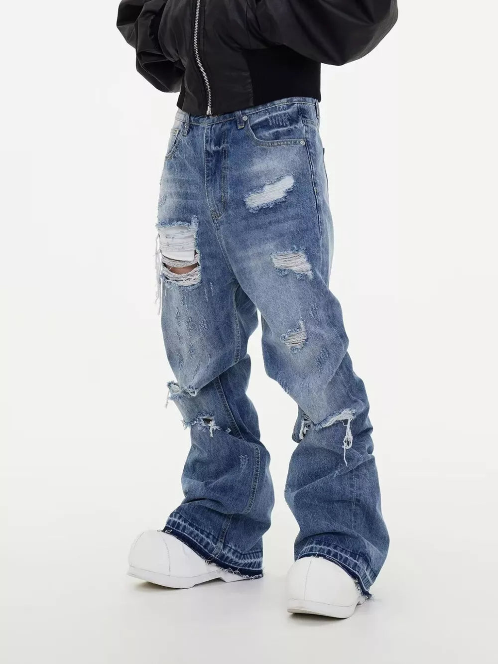 Men's distressed baggy fit blue denim jeans with ripped details.