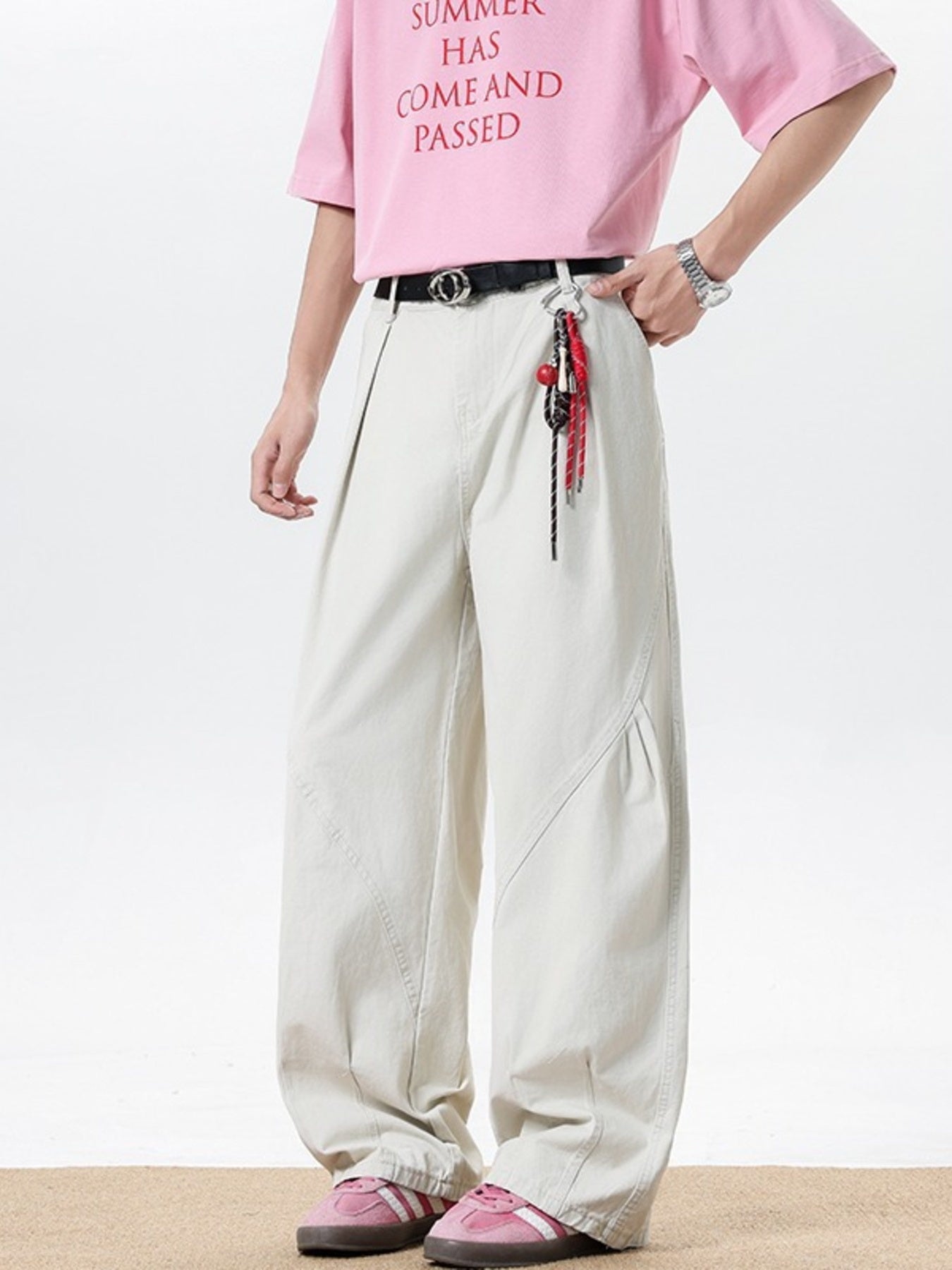 Men's cream pocketed wide leg sweatpants with belt loops and decorative keychain.