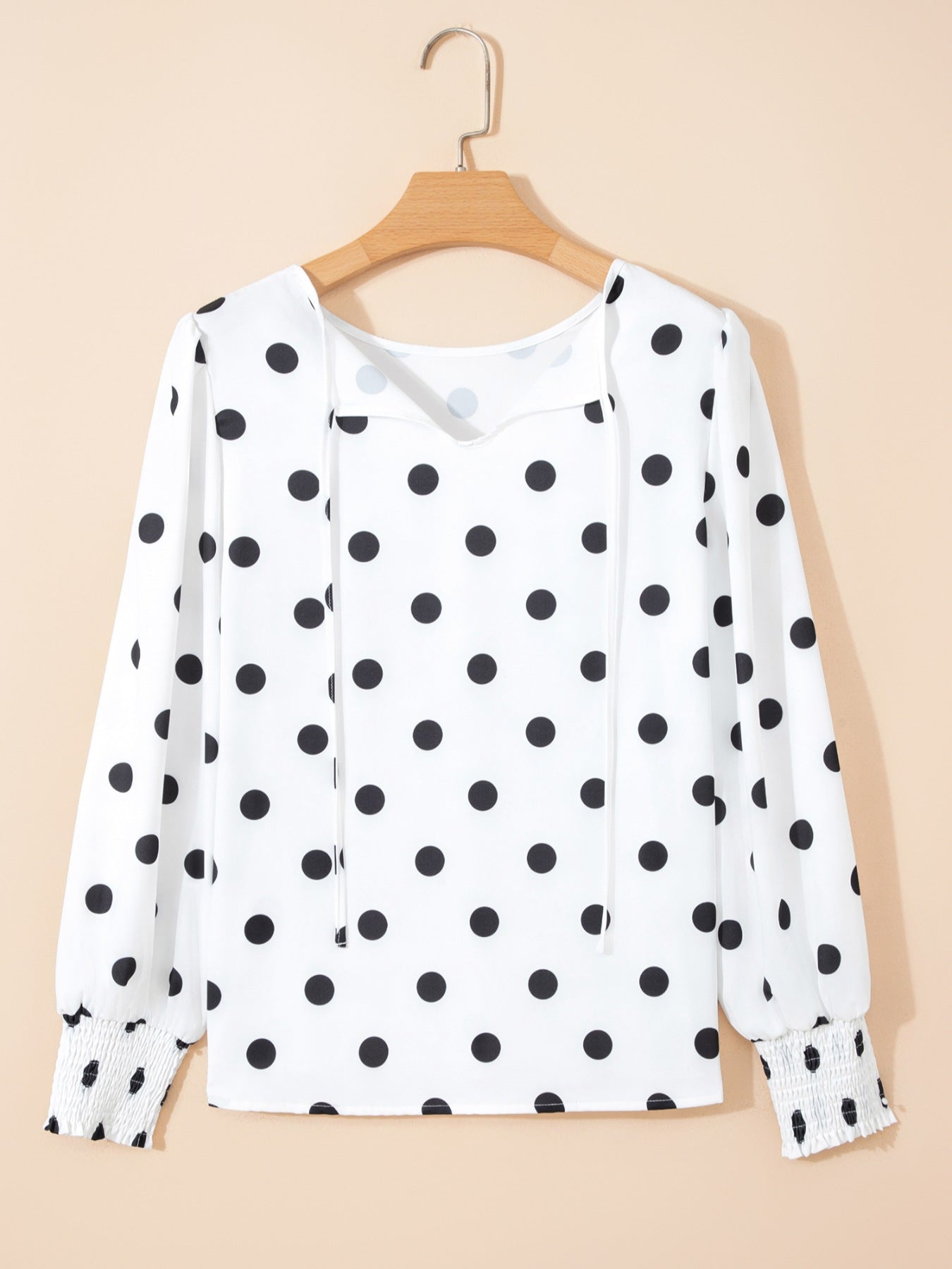 White polka dot blouse with tie neck and smocked cuffs
