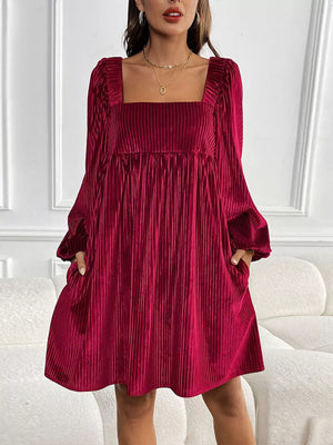 Velvet mini dress with square neckline, long sleeves, and pockets in a rich red hue.