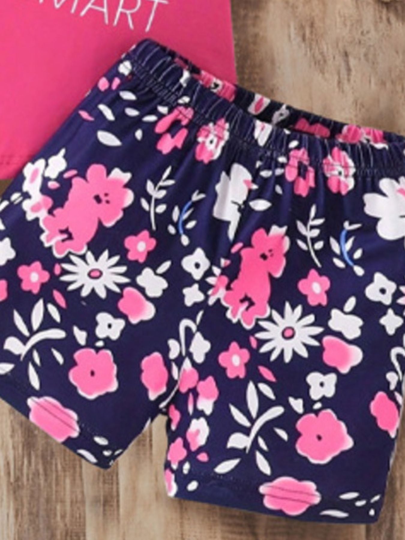 Baby girls' navy floral shorts with pink and white flowers and elastic waistband.